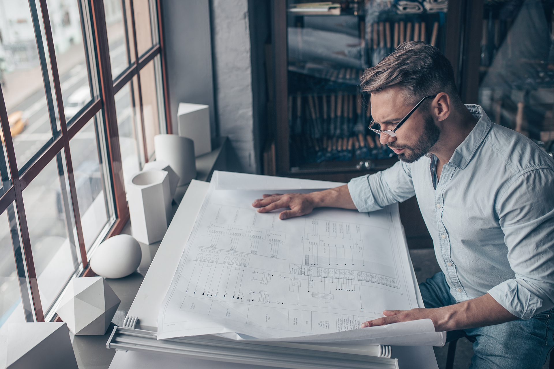 Mature architect with a plan in the studio